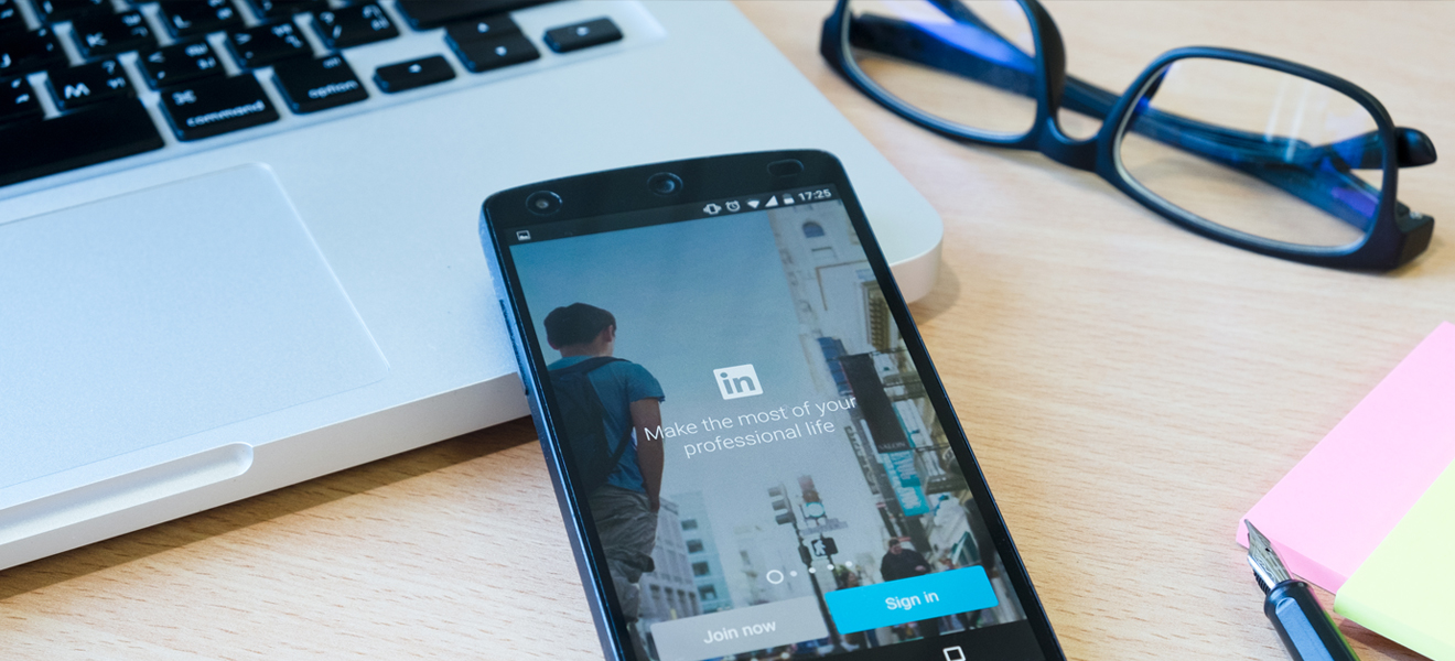 mobile phone on desk displaying linkedin