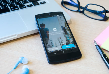 mobile phone on desk displaying linkedin