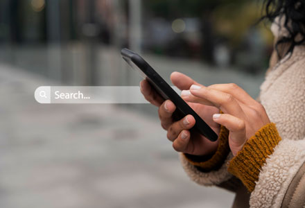 female with mobile phone in hand and a search bar overlaid onto image