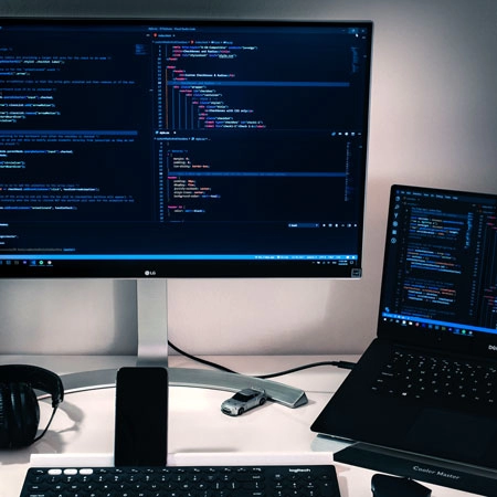 Computer and monitor showing code.