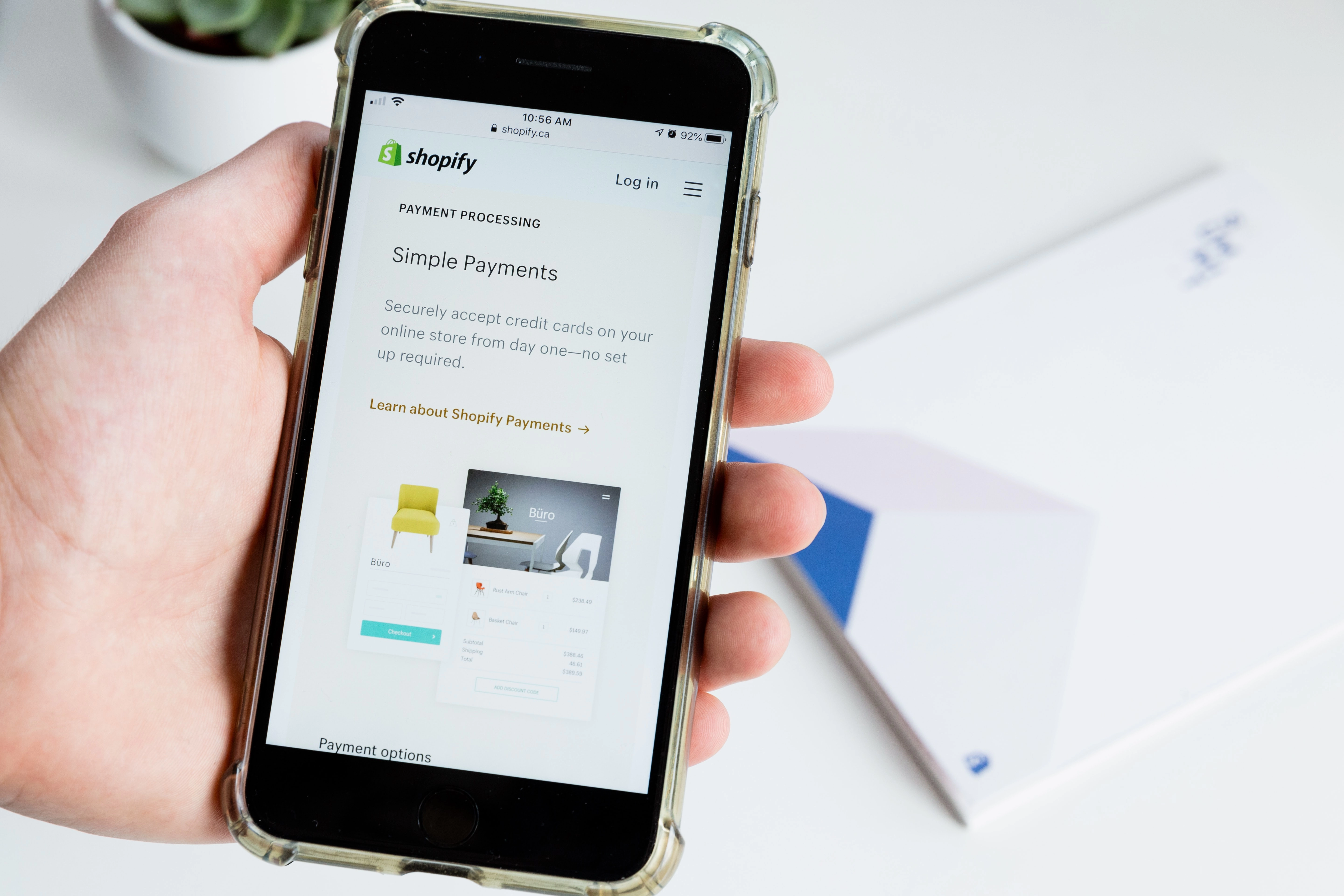 A person using Shopify on a mobile. The page gives information about Shopify's payment processing.