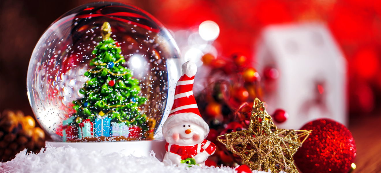 christmas themed image showing snow globe and snowman figurine