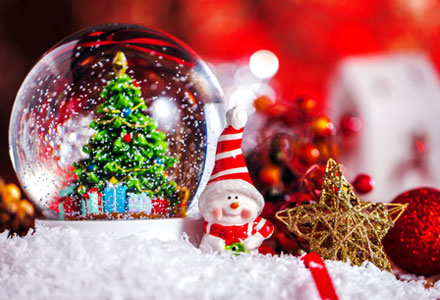 christmas themed image showing snow globe and snowman figurine