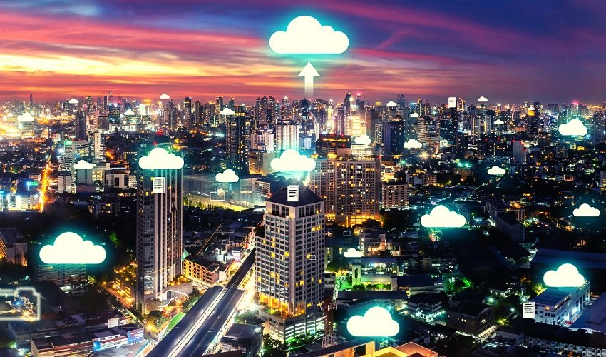 A photo of a digitally enhanced city landscape at sunset, with cloud icons shining above different skyscrapers.