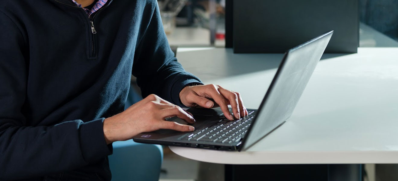 A man typing on a laptop.