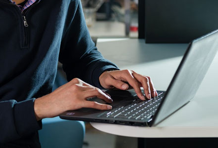 A man typing on a laptop.