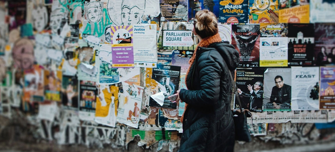 A woman in front of a wall of posters.