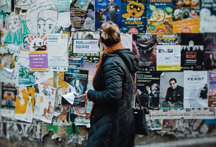 A woman in front of a wall of posters.