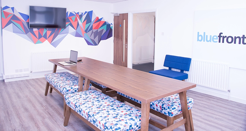 Meeting room with benches and a TV.