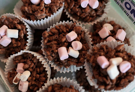 Chocolate crispy cakes with mini marshmallow decorations.