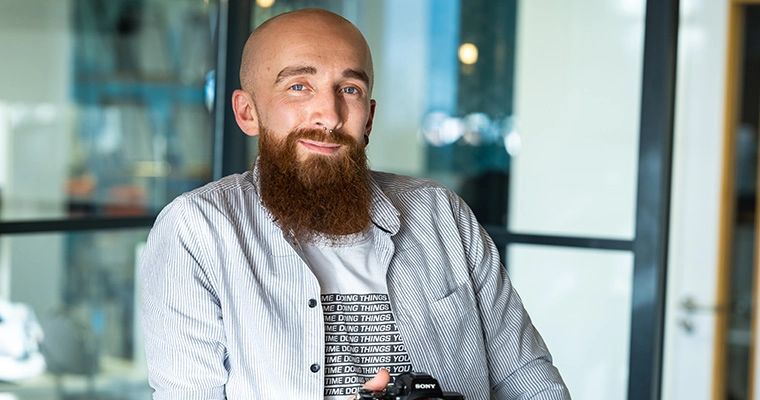 Mike Ingram smiling in the Southampton office, holding his camera