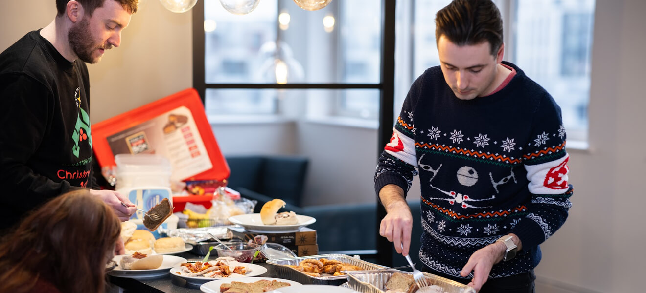 The team eating food from the Xmas buffet spread.