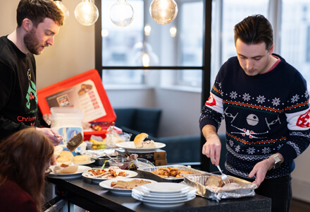 The team eating food from the Xmas buffet spread.