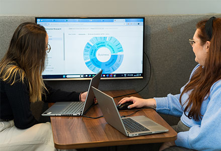 Olivia and Charlotte examining data on a screen.